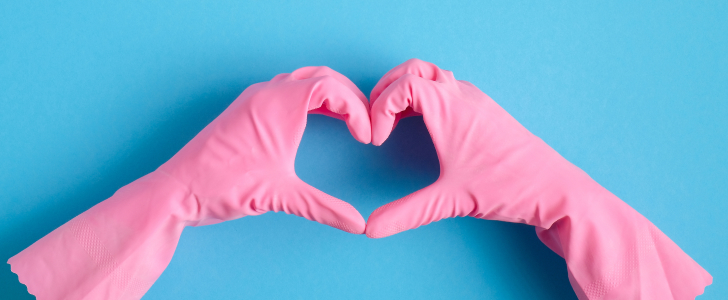 Pink plastic gloves making heart hands
