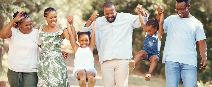 Happy family holding hands walking down path together