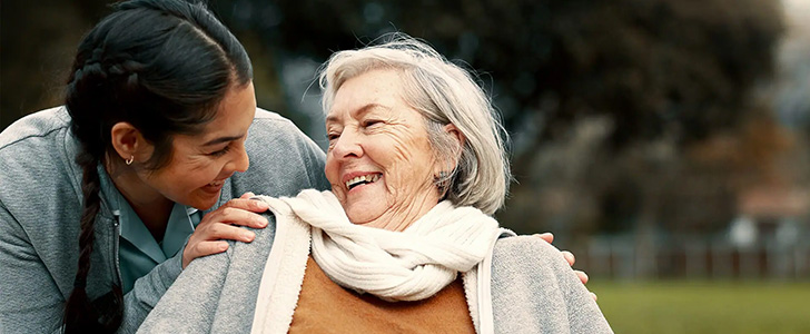 Young woman and senior woman smiling at each other